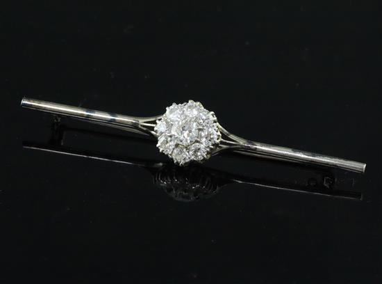 An 18ct white gold, platinum and nine stone diamond cluster set bar brooch, 7cm.